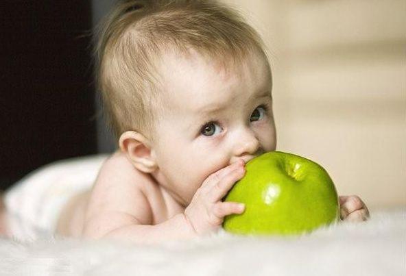 младенец с зеленым яблоком